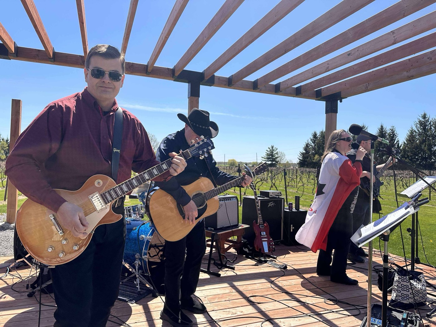 Ross with a Les Paul, Brent in cowboy hat, Gaetana mid-song at VKH Vineyard